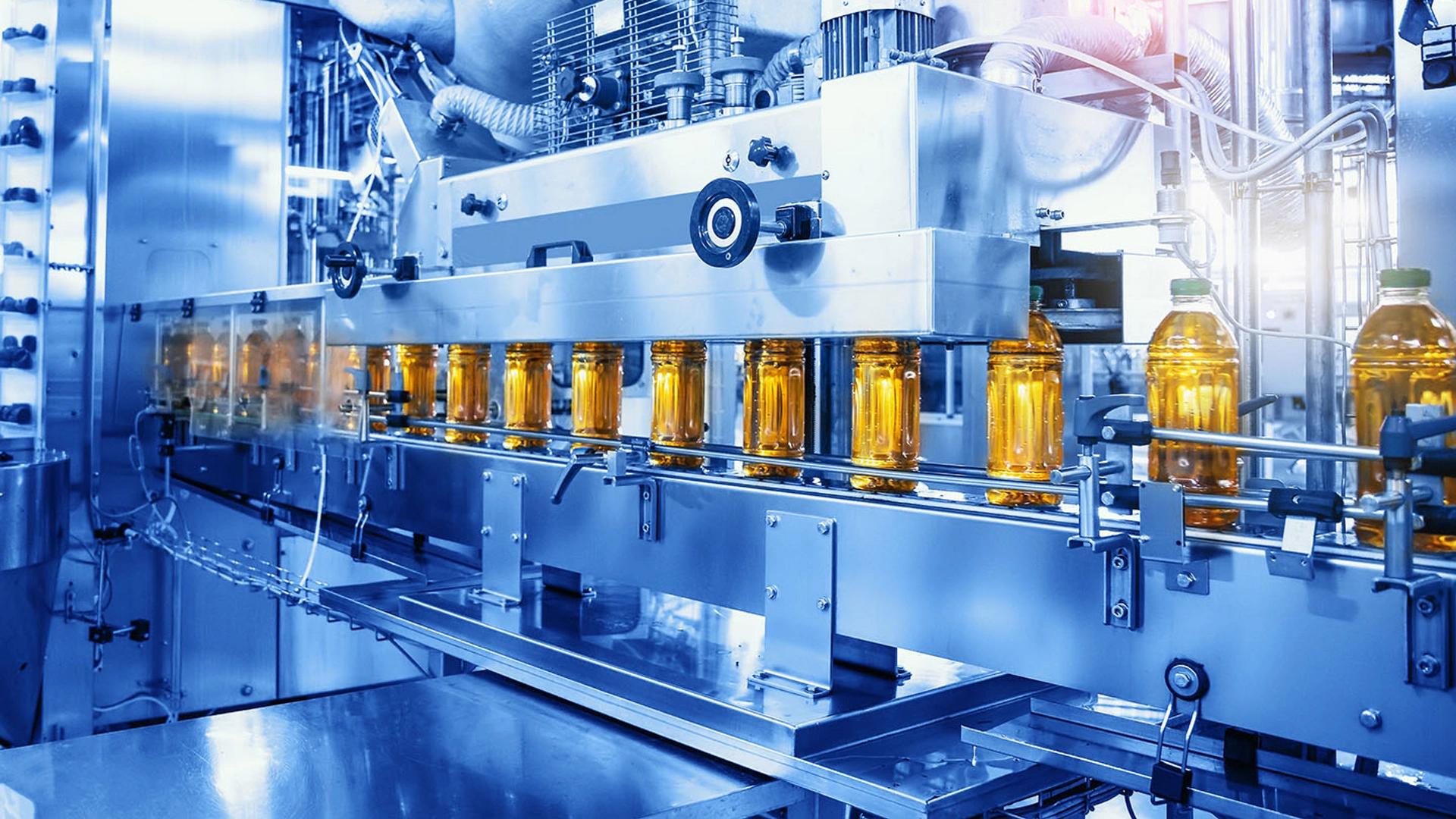 Beverage factory, Conveyor belt with juice in bottles, Industrial Interior in blue color, food and drink production line process.