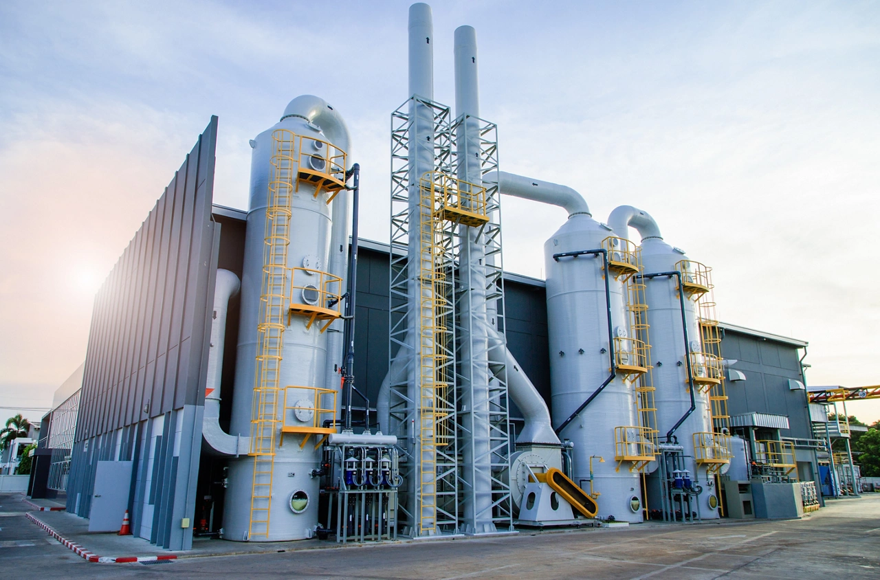 Industrial exhaust air treatment system or wet scrubber system ,Modern industrial plant with a tall exhaust system against a blue sky