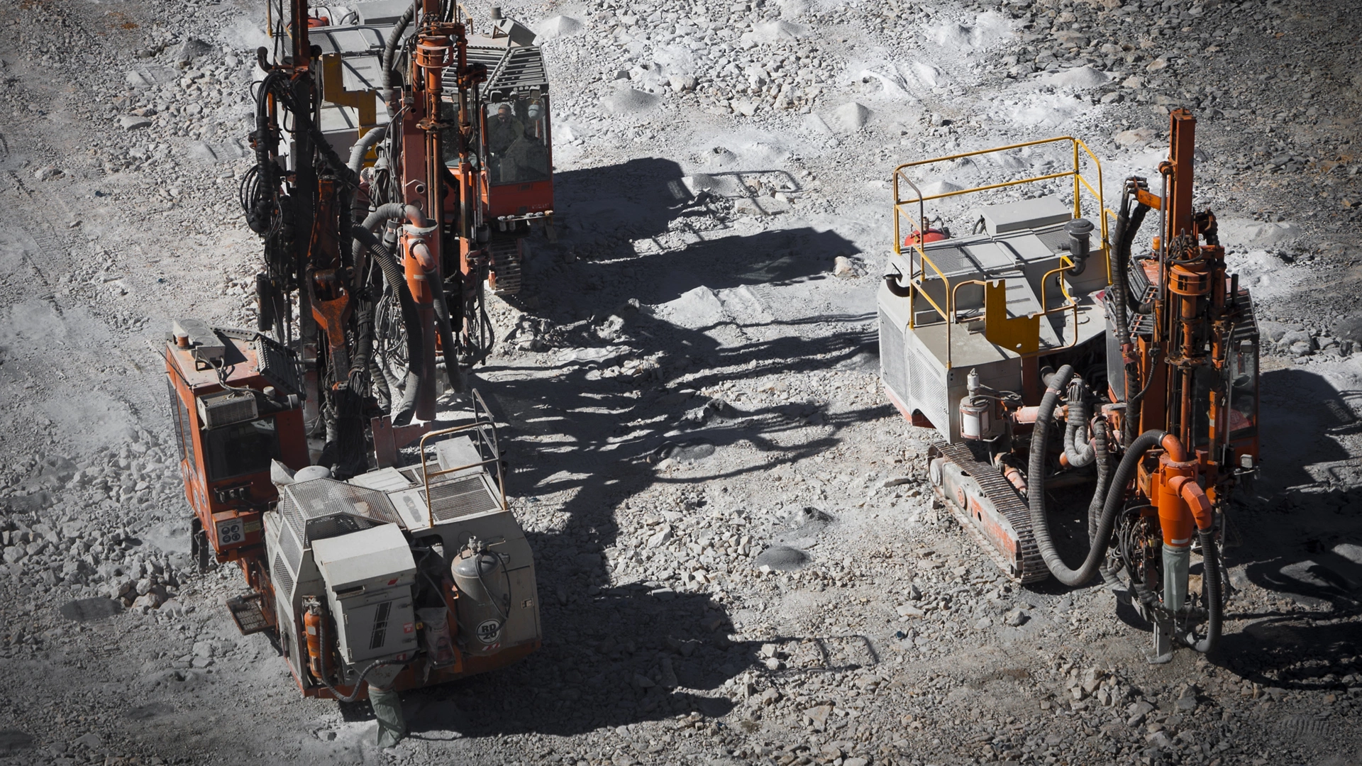 Drilling machine makes bore holes for explosives in open cast mine. Lithium Mine in Western Australia. Spodumene ore from the open cast mine.