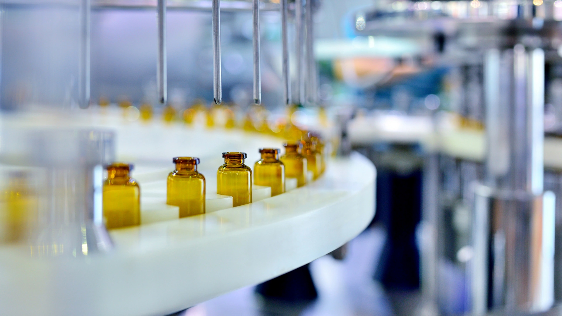 Cloes-up of brown glass bottle filling at production line.