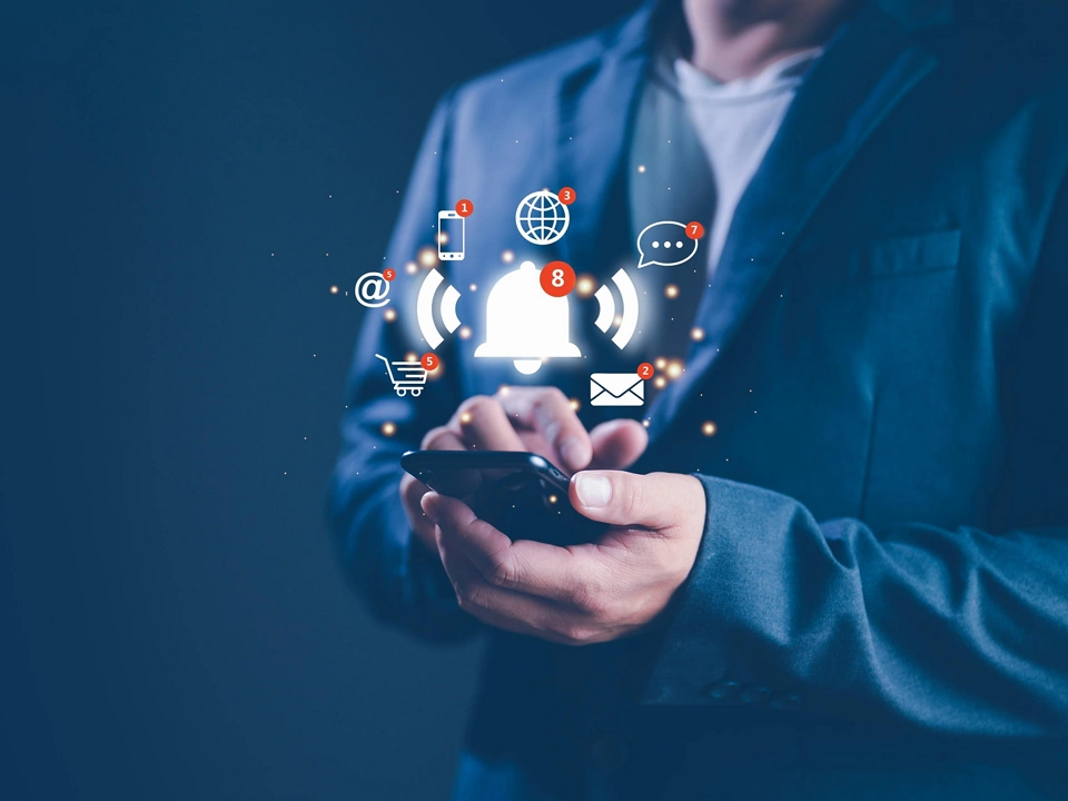 Businessman using smart phone with virtual bell ringing for application notification alert concept. social media and internet network notification alert, email, telephone, chat, shopping online.