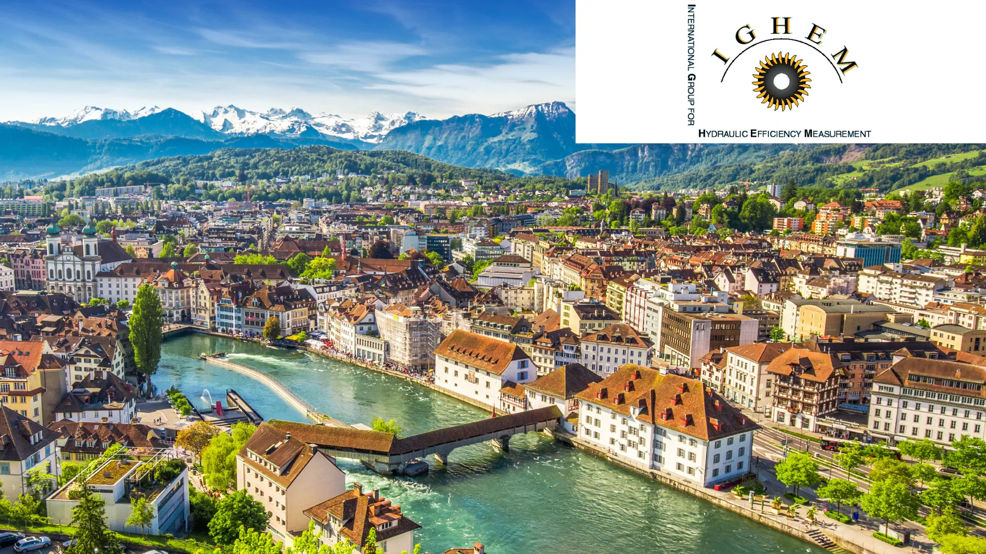 aerial-view-of-historic-city-with-river-covered-bridge-and-mountain-range-background-featuring-international-group-for-hydraulic-efficiency-measurement-ighem-logo