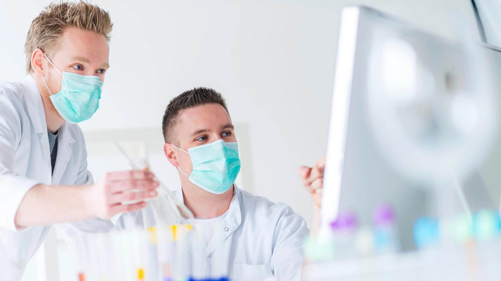 men wearing masks holding beakers in lab Biotech Firm Automates Document Management Save Time Money Improve Compliance
