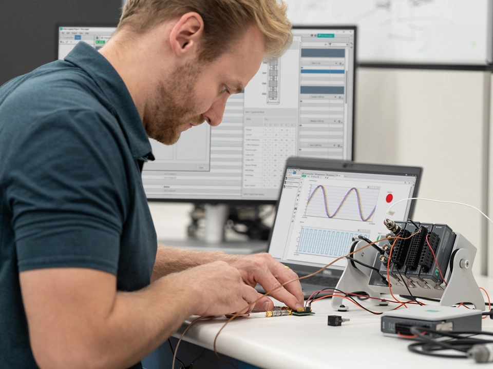 Engineer using NI hardware and software for data acquisition in a laboratory setting.