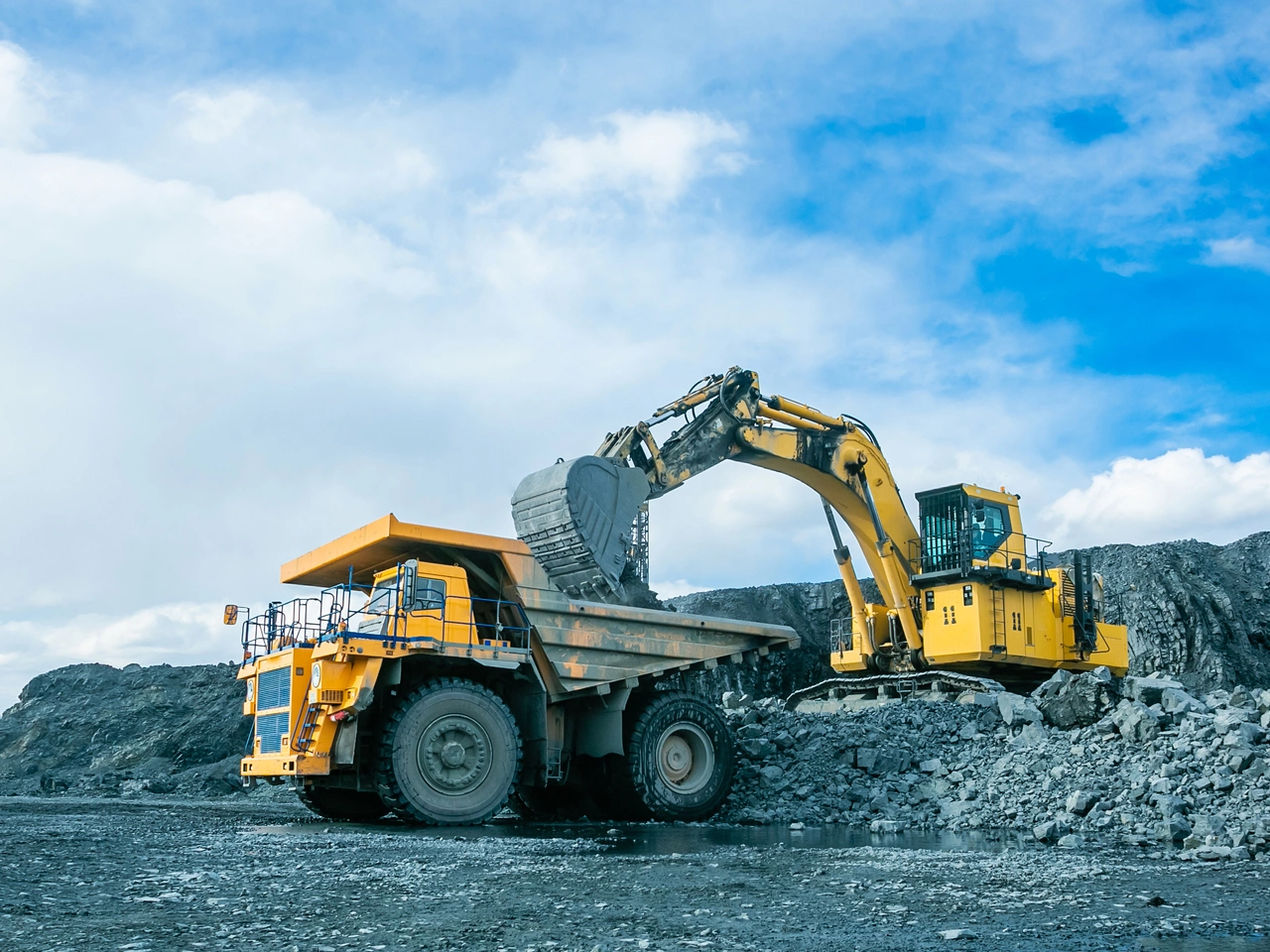 Work of trucks and the excavator in an open pit on gold mining, soft focus