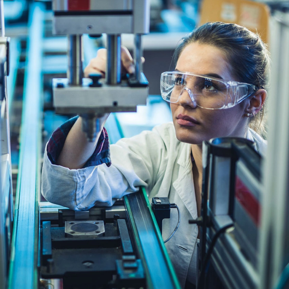 Woman in lab coat working with equipment