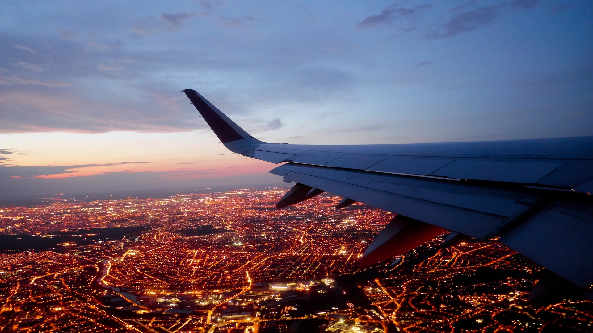 Wing of modern aircraft flying above Paris at night