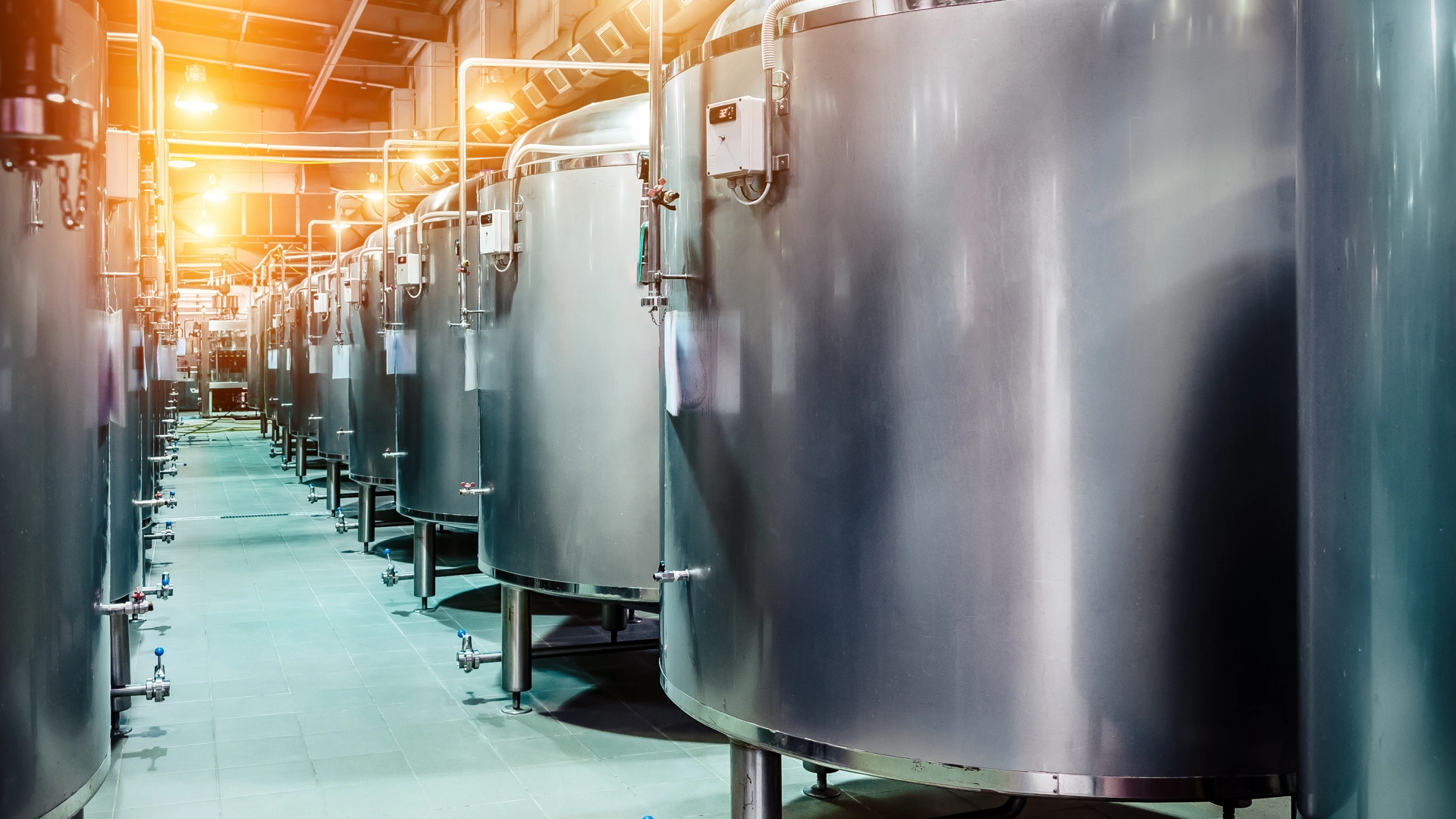 Modern Beer Factory. Rows of steel tanks for beer fermentation and maturation. Spot light effect