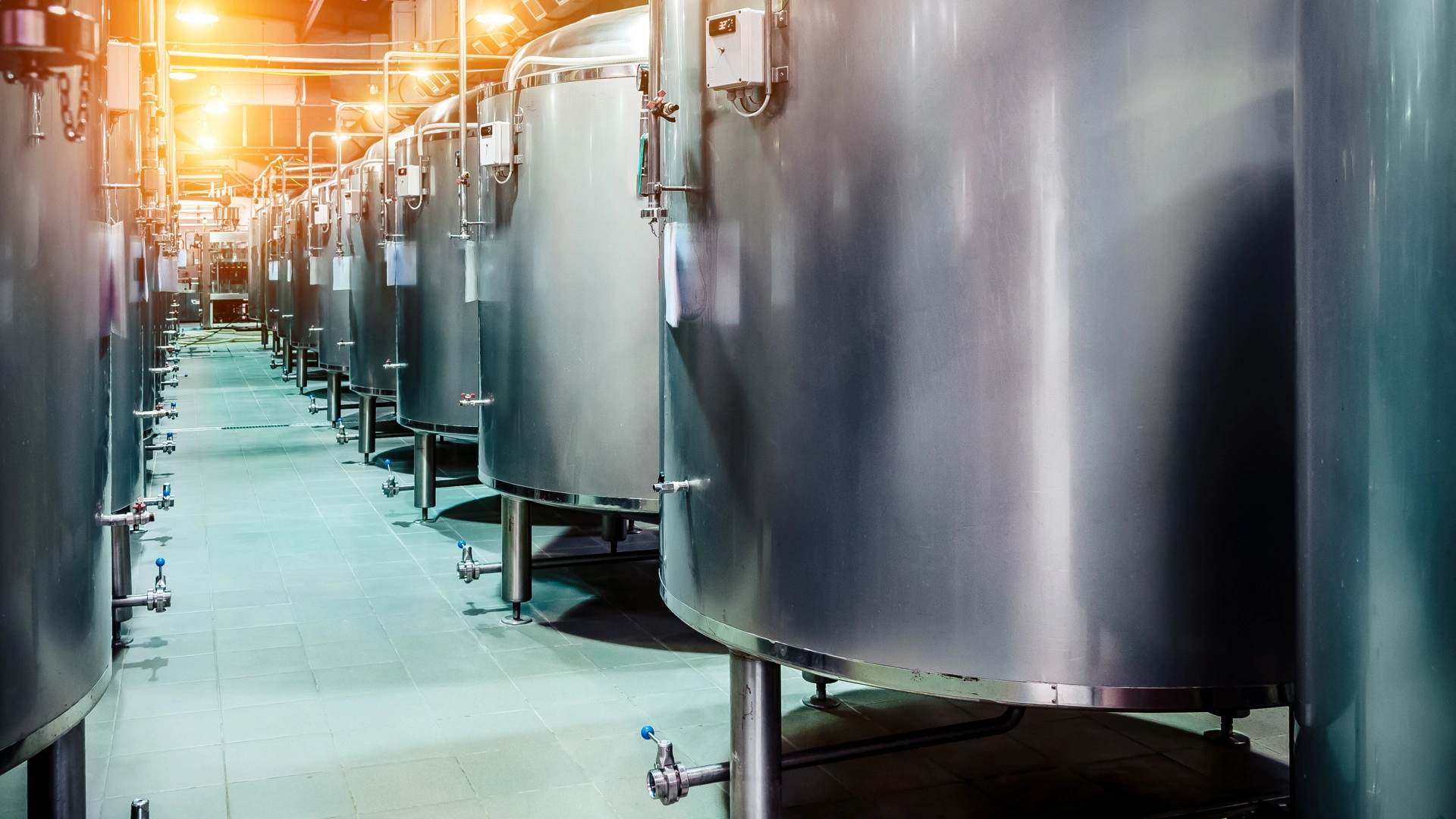 Modern Beer Factory. Rows of steel tanks for beer fermentation and maturation. Spot light effect
